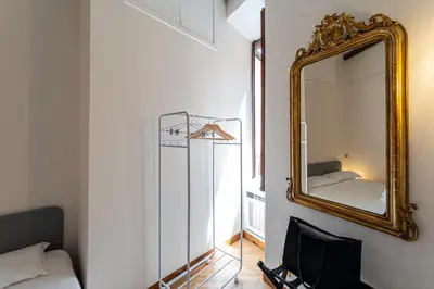 a mirror hanging on a wall next to a bed at Margana Luxury 3 bedrooms amazing terrace in Rome