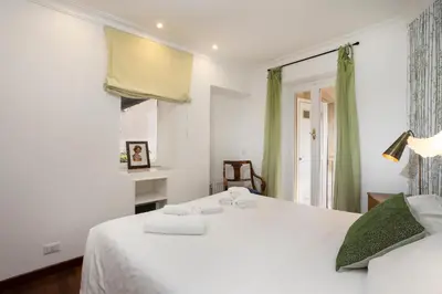 a bedroom with a white bed and a window at Cozy Gambero Apartments in Rome