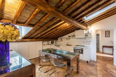 a kitchen with wooden ceilings and a glass table at Cozy Gambero Apartments in Rome