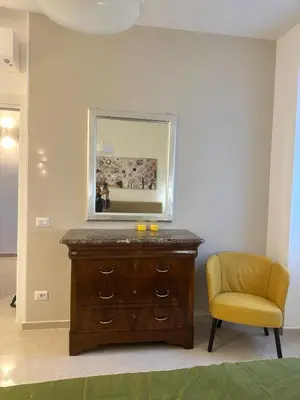 a dresser with a mirror and a yellow chair at Welcome to Campo De' Fiori in Rome