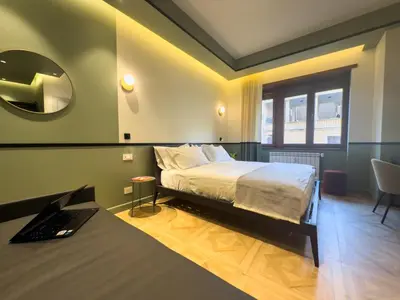a bedroom with a bed and a mirror and a desk at Vatican Domus Stefania Guest House in Rome