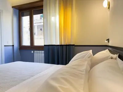 a bed with white sheets and a window at Vatican Domus Stefania Guest House in Rome