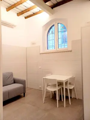 a room with a table and a chair and a window at Caprareccia Apartment in Rome