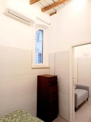 a bedroom with a bed and a dresser and a window at Caprareccia Apartment in Rome