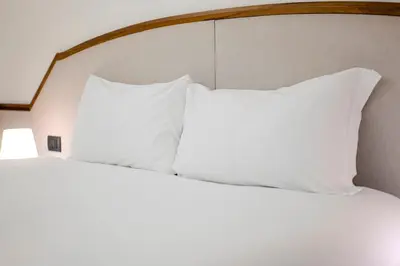 a bed with white pillows and a wooden headboard at Restart Accommodations Pantheon in Rome