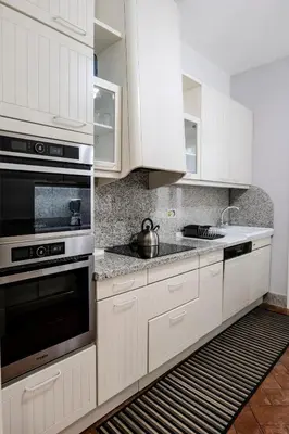 a kitchen with white cabinets and a stove top oven at Restart Accommodations Pantheon in Rome