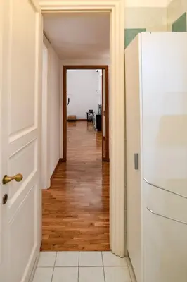 a hallway with a white door and a white refrigerator at Restart Accommodations Dea Roma in Rome