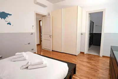 a white bedroom with two white towels on a bed at Restart Accommodations Dea Roma in Rome