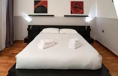 a large white bed with two white towels on it at Restart Accommodations Dea Roma in Rome