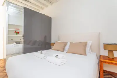 a bedroom with a large white bed with a mirror at Navona Urban Sanctuary in Rome