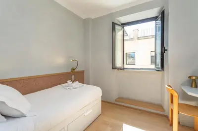 a white bedroom with a bed and a window at Spanish Steps Exclusive 3BDR in Rome