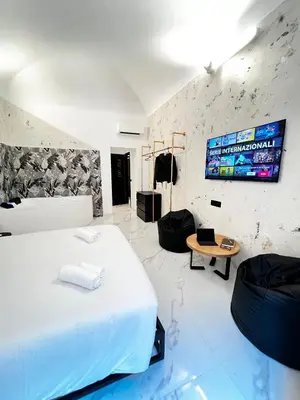 a bedroom with a bed and a tv on the wall at ESE luxury spa suites - Private Jacuzzi Rooms Near Termini, Perfect for Winter in Rome