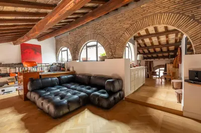 a living room with a leather couch and a kitchen at Monti Designer Loft by Romeloft in Rome