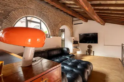 a living room with a leather couch and a lamp at Monti Designer Loft by Romeloft in Rome