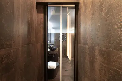 a bathroom with a toilet and a glass door at Luxury Loft Campo Dè Fiori in Rome