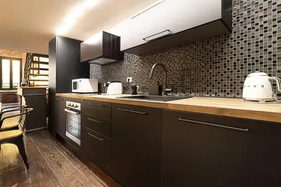 a kitchen with black cabinets and a sink at Luxury Loft Campo Dè Fiori in Rome