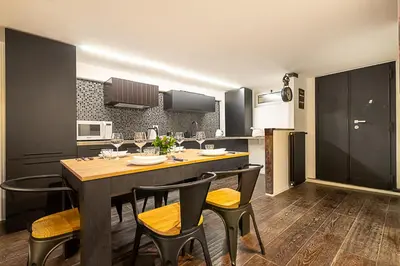 a kitchen with a table and chairs in a kitchen at Luxury Loft Campo Dè Fiori in Rome