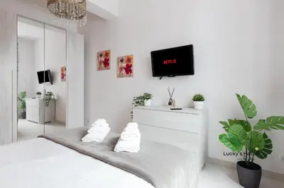 a white bedroom with a bed and a tv on the wall at Lucky's House - 400mt to Metro A, 3 bedrooms, 6-8 pax, A-C, Roma in Rome