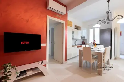 a kitchen and dining room with a tv on a wall at Lucky's House - 400mt to Metro A, 3 bedrooms, 6-8 pax, A-C, Roma in Rome