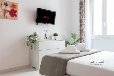 a bedroom with a bed and a tv on a wall at Lucky's House - 400mt to Metro A, 3 bedrooms, 6-8 pax, A-C, Roma in Rome