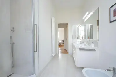 a white bathroom with a shower and a sink at Vatican Basilica Apartment in Rome