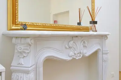 a mirror sitting on top of a white fireplace at Vatican Basilica Apartment in Rome