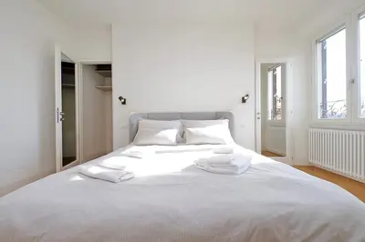 a white bed with two white towels on it at Vatican Basilica Apartment in Rome