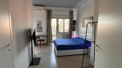 a bedroom with a blue bed and a desk at La casa di Ezechiele in Rome