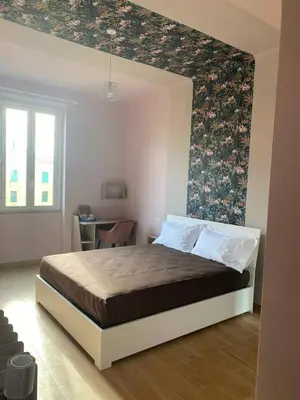 a bedroom with a bed with a floral wall at San Giovanni Living House 2 in Rome