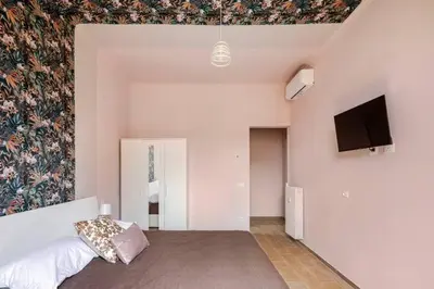 a room with a bed and a flat screen tv at San Giovanni Living House 2 in Rome