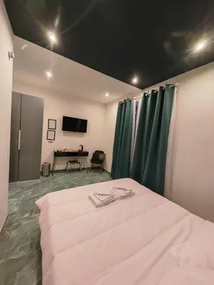 a bedroom with a white bed with green curtains at Cozy Luxury room San Pietro in Rome