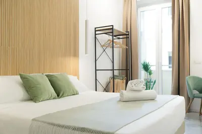 a bedroom with a white bed and a chair at Lilla Suites - Musei Vaticani in Rome