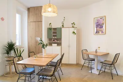 a room with two tables and chairs and a refrigerator at Lilla Suites - Musei Vaticani in Rome