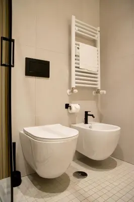 a white bathroom with a toilet and a sink at Lilla Suites - Musei Vaticani in Rome