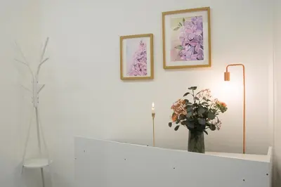 a white room with a vase of flowers on a mantle at Lilla Suites - Musei Vaticani in Rome