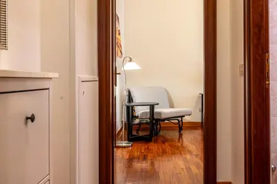 a room with a chair and a table and a lamp at La Tua Casa al Colosseo in Rome