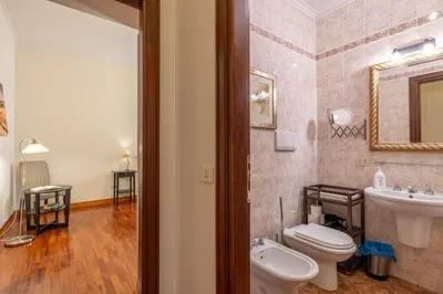 a bathroom with a toilet and a sink and a mirror at La Tua Casa al Colosseo in Rome