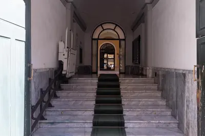 an empty hallway of a building with stairs leading to a door at La Tua Casa al Colosseo in Rome