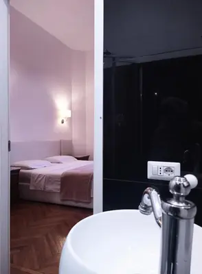 a room with a bed and a bathroom with a sink at GH Lorvand in Rome