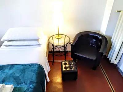 a bedroom with a bed and a chair and a table at GH Lorvand in Rome