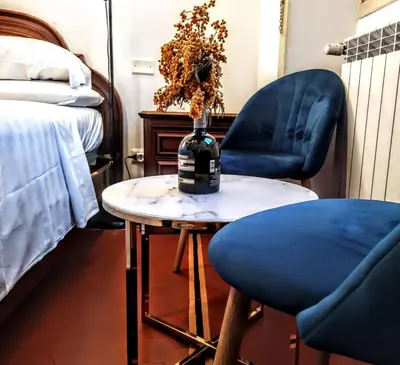 a bottle of wine sitting on a table with a chair at GH Lorvand in Rome