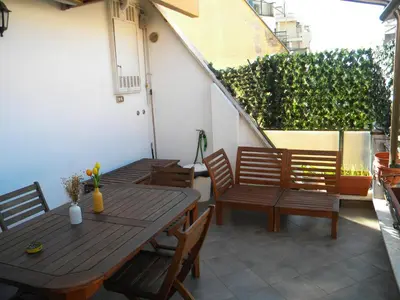 a patio with wooden tables and chairs on a balcony at Terrazzo Trieste-Africano in Rome