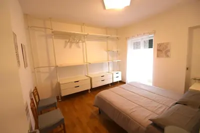 a bedroom with a bed and a chair and a window at Terrazzo Trieste-Africano in Rome
