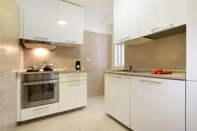a kitchen with white cabinets and a stove at Oriana Homèl Roma in Rome