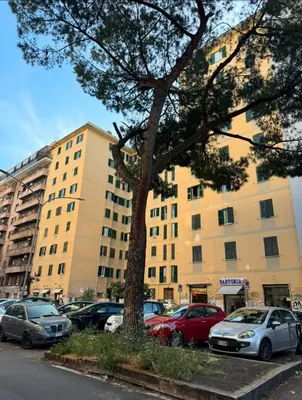 a parking lot with cars parked in front of a building at cosy apt close to metro San Paolo in Rome