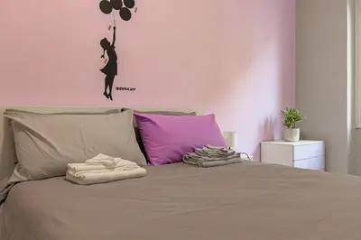 a bedroom with a bed with a woman jumping on it at cosy apt close to metro San Paolo in Rome