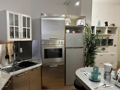 a kitchen with a stainless steel refrigerator and a sink at Tiburtina68 central apartment in Rome