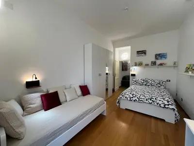 a white bedroom with a bed and a couch at Tiburtina68 central apartment in Rome