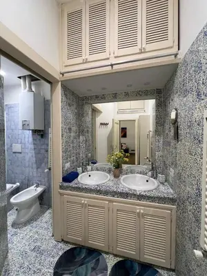 a bathroom with two sinks and a toilet and a mirror at Tiburtina68 central apartment in Rome