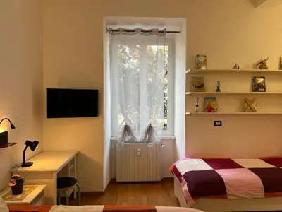 a bedroom with a bed and a desk and a window at Tiburtina68 central apartment in Rome